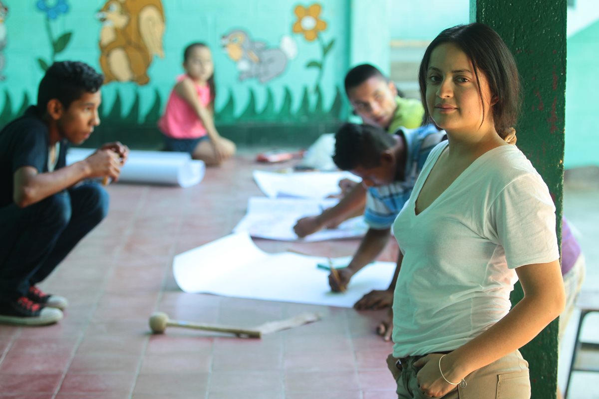 Jazmín Carrillo junto con los niños de la escuela que son beneficiados con la red de amigos que esta migrante formó en Estados Unidos Foto: Álvaro Interiano