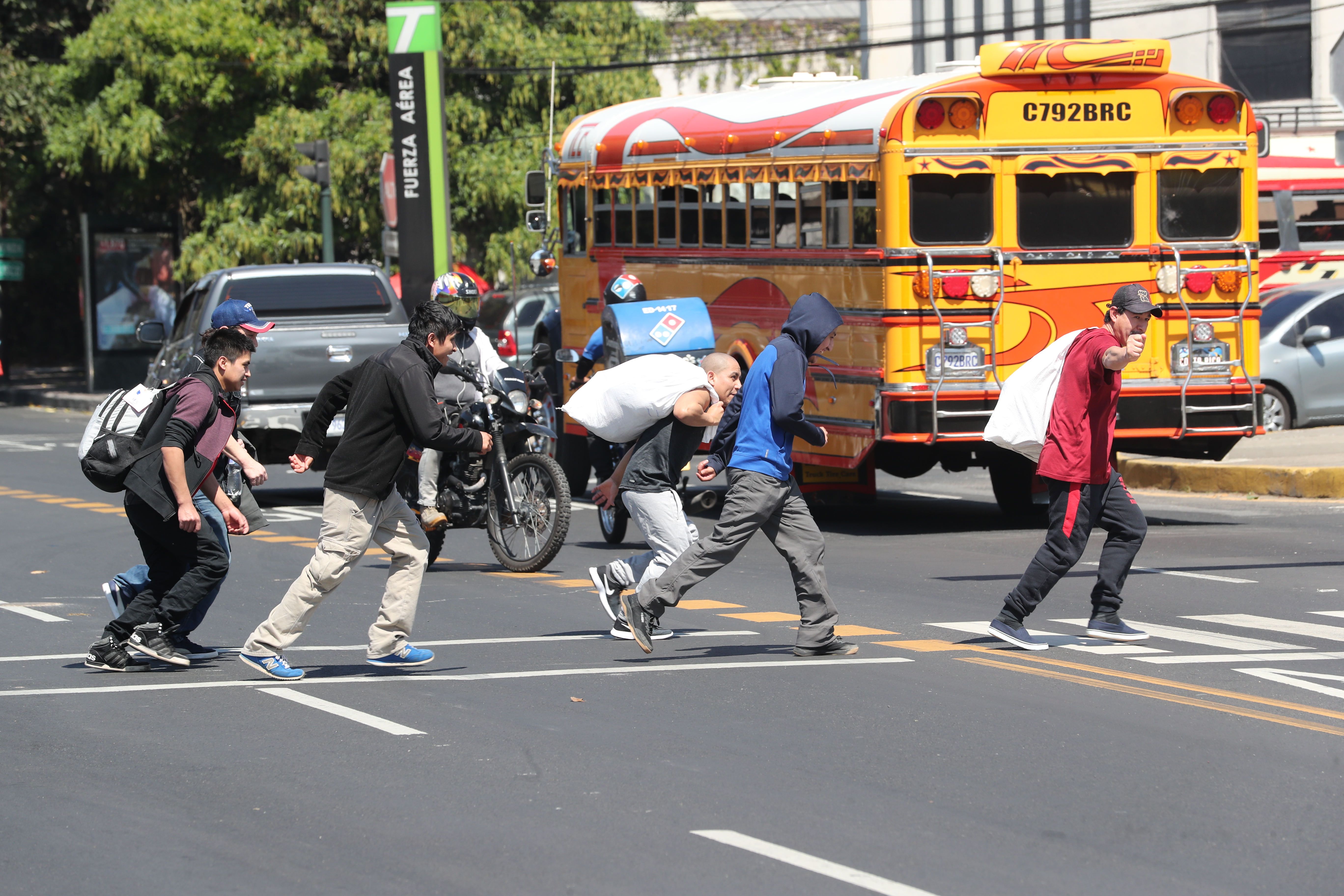 Un grupo de migrantes cruza la Avenida Hincapié en busca de un bus. Recién llegaron deportados desde EE. UU. (Foto Prensa Libre: Érick Ávila)