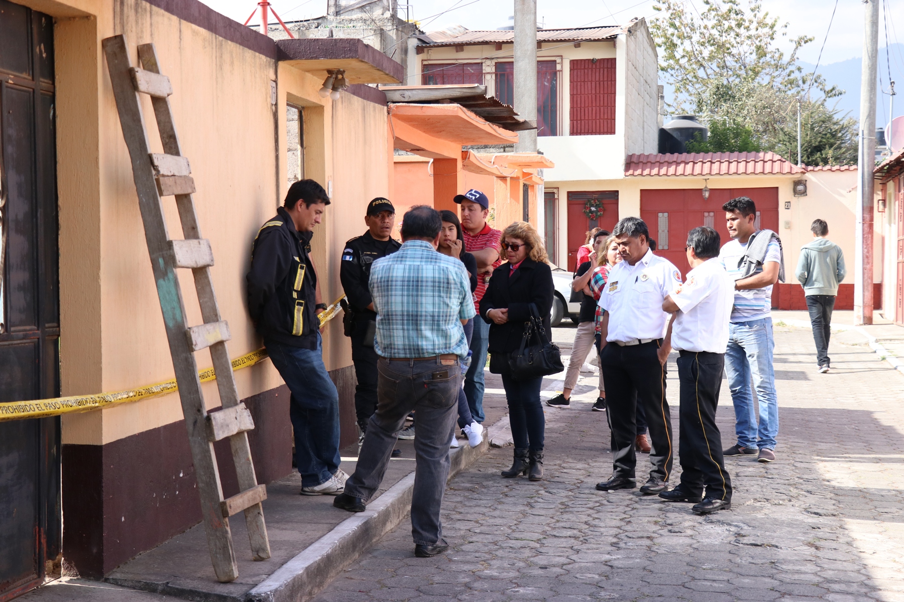 Familiares de las victimas y bomberos esperan en el exterior de la vivienda donde ocurrió el hecho, mientras el MP recolecta evidencias. (Foto Prensa Libre: María Longo) 