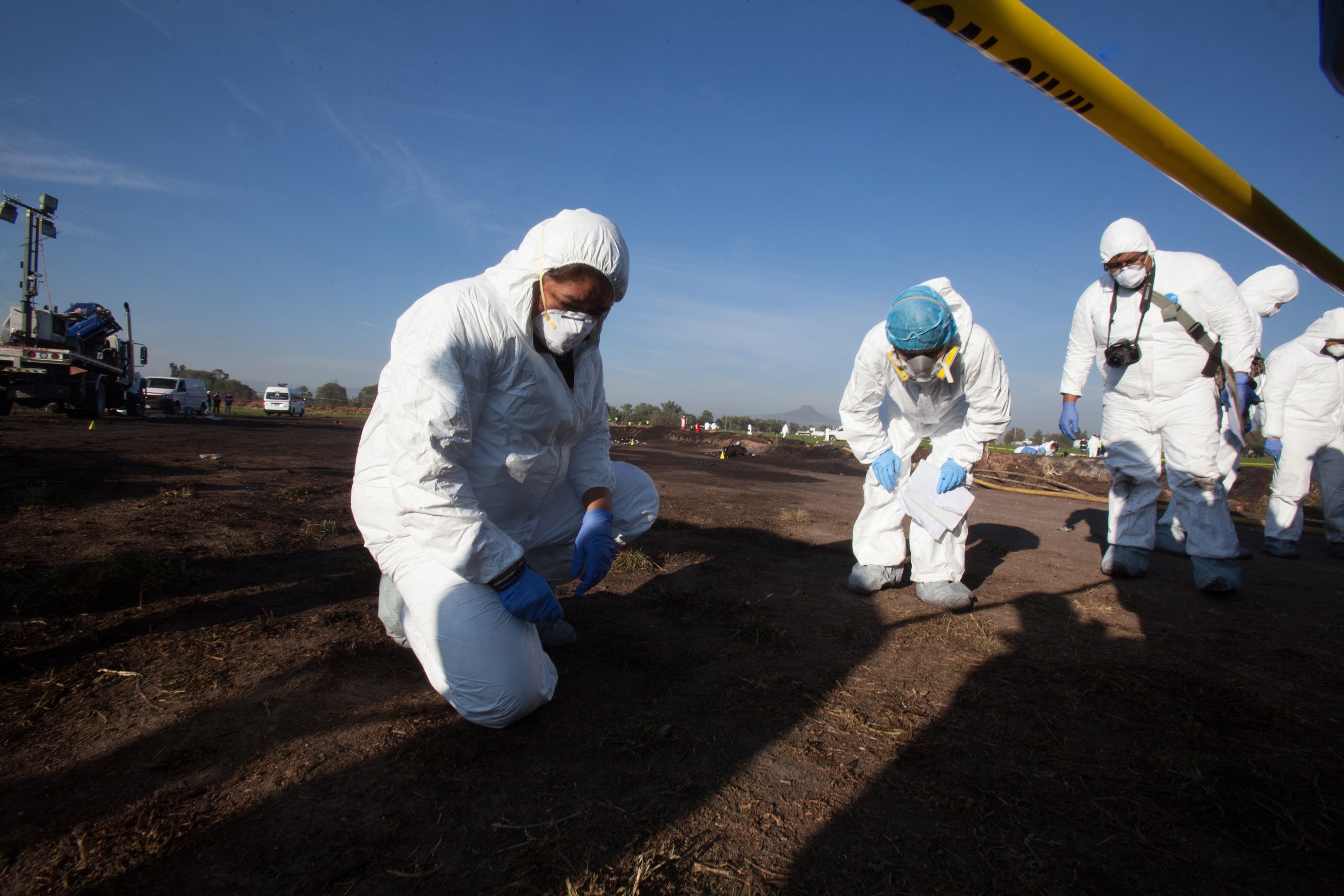 Expertos forenses registran la zona cerca de una toma clandestina de gasolina de Petróleos Mexicanos (Pemex). (Foto Prensa Libre: EFE)