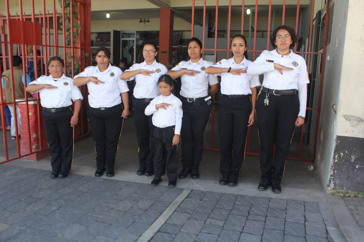 Las damas bomberas unen sus manos con la de la niña Daniela Palacios, de la brigada infantil, como muestra de unidad para servir al prójimo. (Foto Prensa Libre: Fred Rivera).