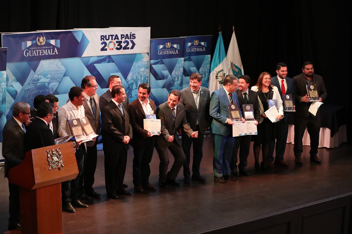 El presidente Jimmy Morales bromea con los alcaldes galardonados, durante la toma de la fotografía oficial del evento, en el Teatro de Don Juan, zona 1. (Foto Prensa Libre: E. García)