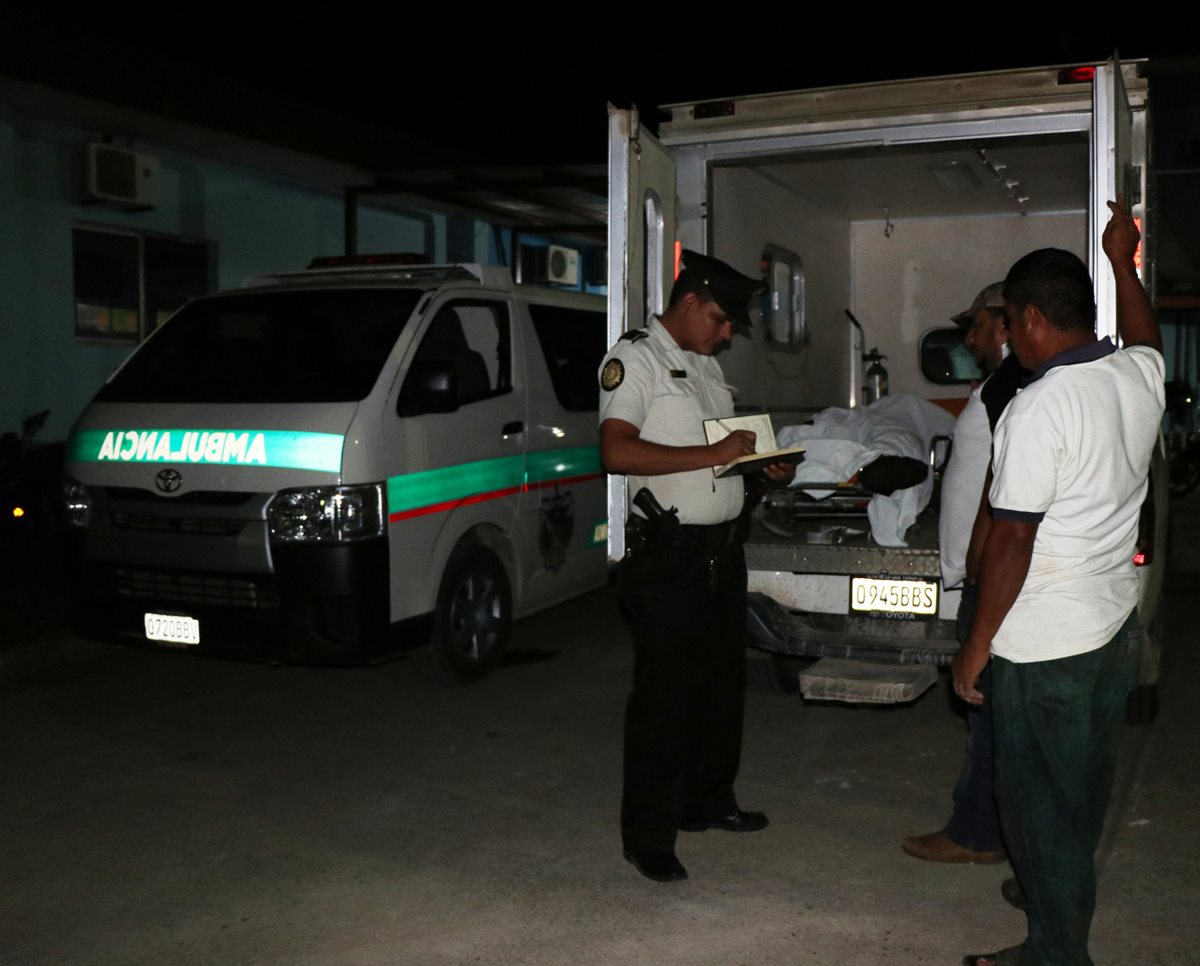 Un agente policial recolecta información sobre el ataque armado, afuera de la sala de urgencias del hospital regional de San Benito, incidente que dejó a una pareja de hermanos muertos. Foto Prensa Libre: Rigoberto Escobar.