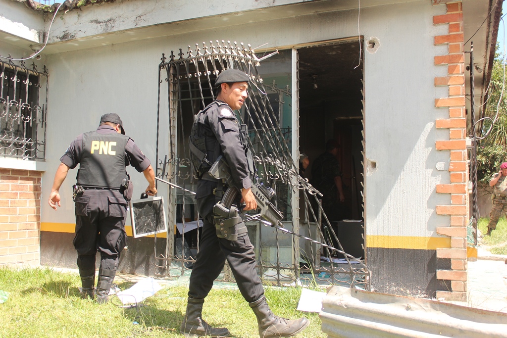 Agentes de la PNC de Santa Eulalia, Huehutenango,limpian subestación que destrozó turba. (Foto Prensa Libre: Mike Castillo)