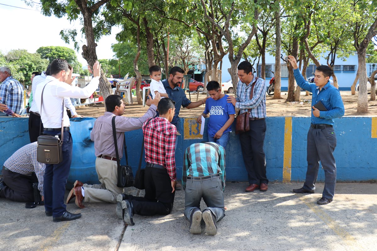 Un grupo de personas ora por el padre para que tenga fuerza, para superar la muerte de su hija. (Foto Prensa Libre: Mario Morales)