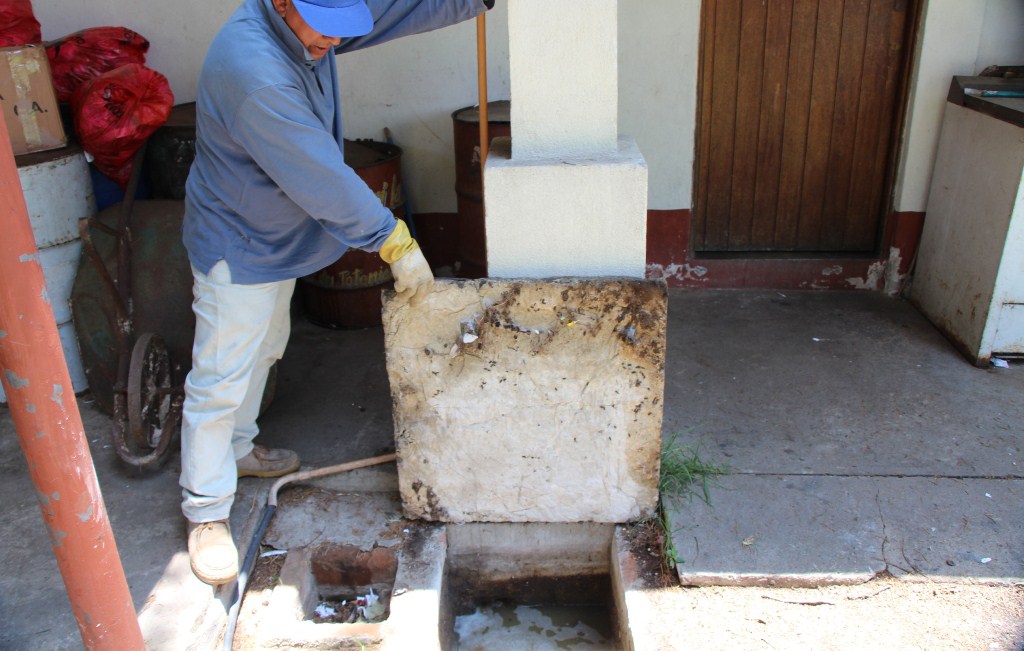 Trabajador del Área de Salud muestra alcantarillado que permanece obstruido en el centro de Salud de la cabecera. (Foto Prensa Libre: Édgar Domínguez).