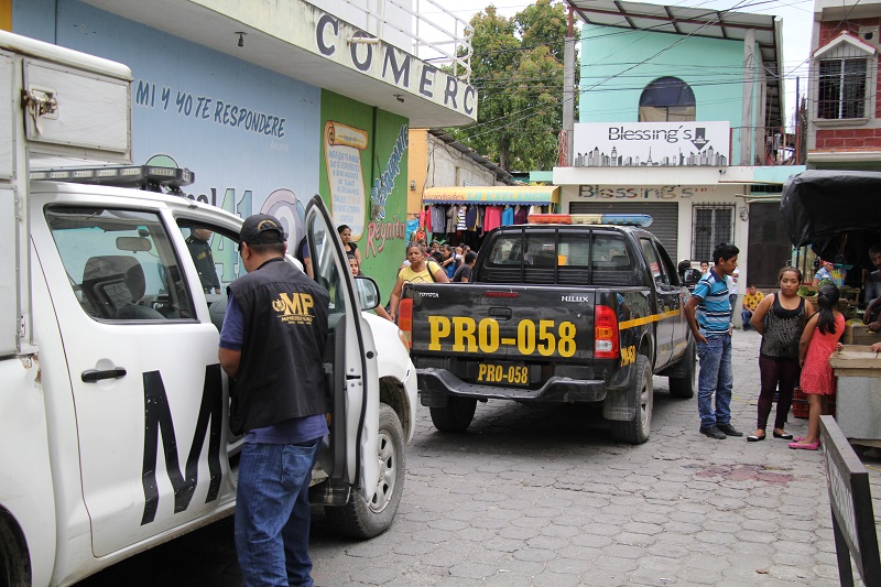 Las autoridades, durante el procesamiento de la escena del ataque armado en el que murió un hombre y resultaron heridas dos mujeres y una niña, quien falleció este domingo. (Foto Prensa Libre: Hugo Oliva)