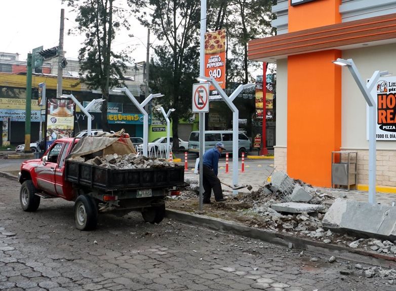 Un trabajadore retira restos de mesas y bancas frente a una pizzería que se halla en la zona 3 de Quetzaltenango. (Foto Prensa Libre: Carlos Ventura)