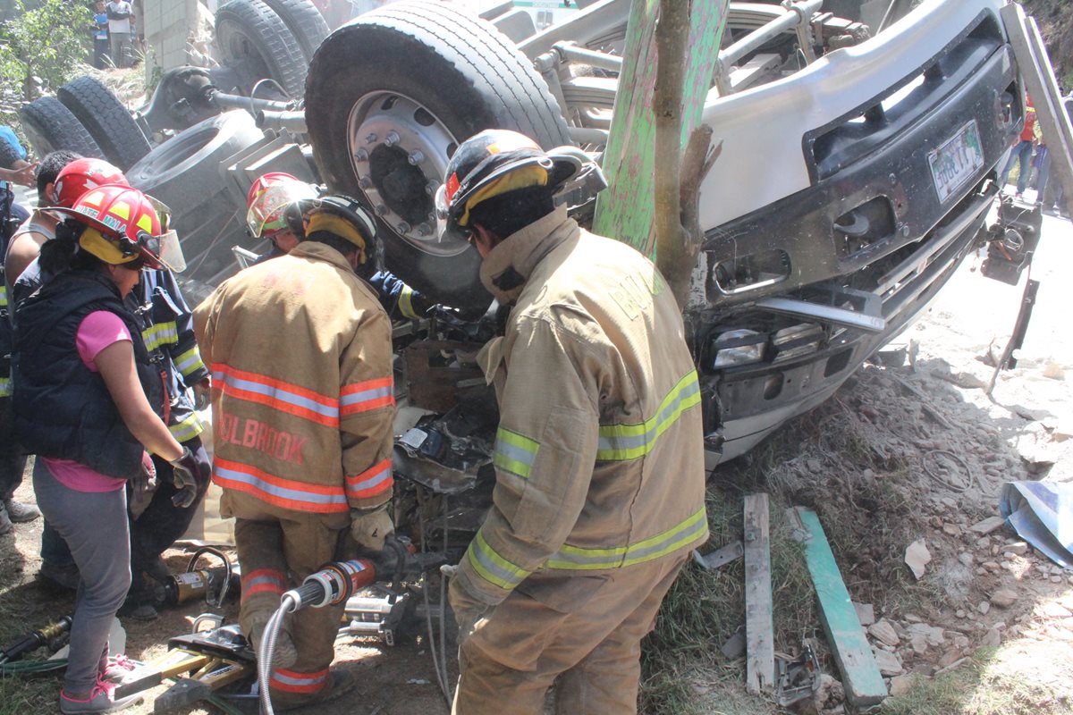 Socorristas utilizan equipo hidráulico para sacar cadáver de Alejandro Panjoj. (Foto Prensa Libre: Ángel Julajuj)