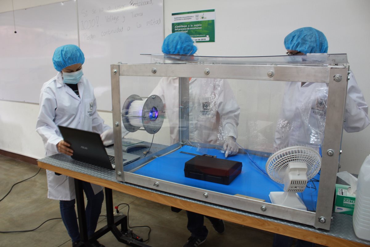 Los estudiantes deben vestir equipo de protección personal cuando utilizan la caja limpia, para evitar que los componentes del CubeSat se impregnen de suciedad. (Foto Prensa Libre, Proyecto CubeSat)