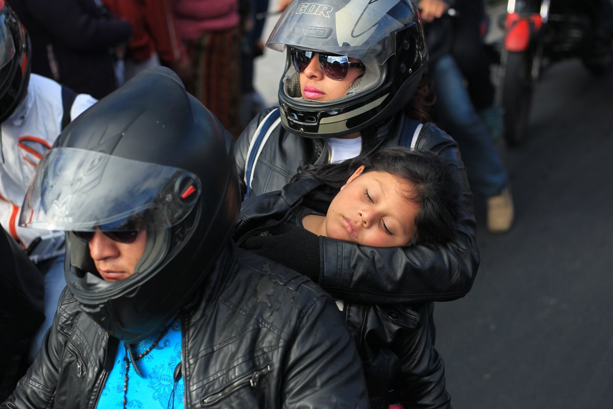 Un niño duerme en los brazos de su madre a bordo de una motocicleta; ignora que su vida corre peligro. (Foto Prensa Libre: Esbin García)