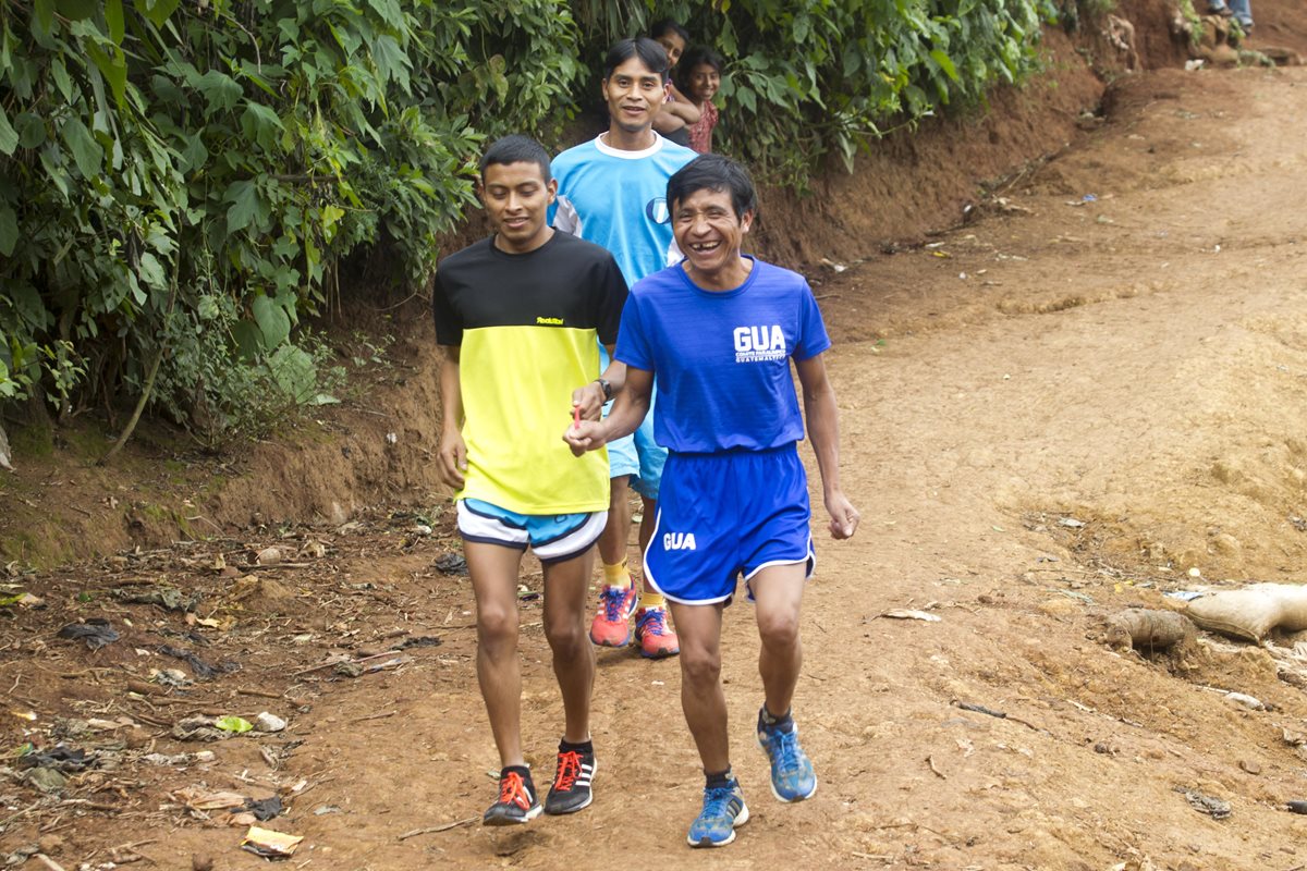 Santos Martínez guía a Óscar Raxón durante un entrenamiento en Los Trojes, San Juan Sacatepéquez. Atrás corre su hermano Freddy. (Foto Prensa Libre: Norvin Mendoza)