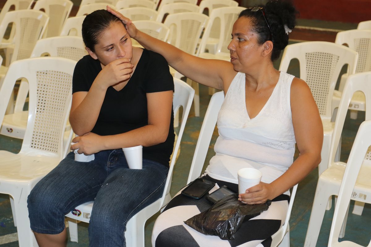 Mirna Palma, madre del menor, es consolada por una vecina. (Foto Prensa Libre: Edwin Paxtor)