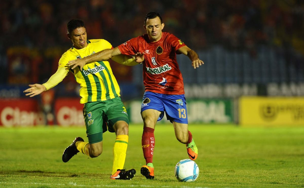 Marco Pappa cubre la pelota de la marca del defensa de Guastatoya Carlos Gallardo. (Foto Prensa Libre: Francisco Sánchez)