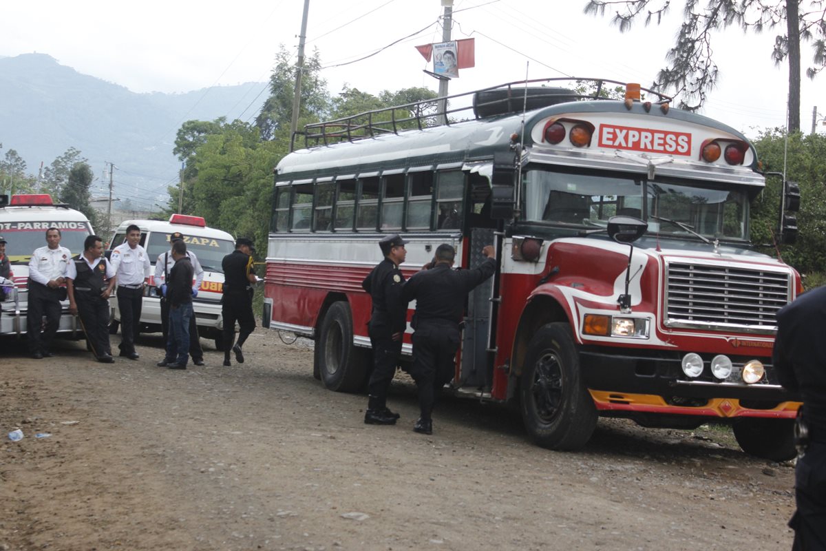 Agentes de la PNC inspeccionan el autobús en el que ocurrió el ataque. (Foto Prensa Libre: Víctor Chamalé)