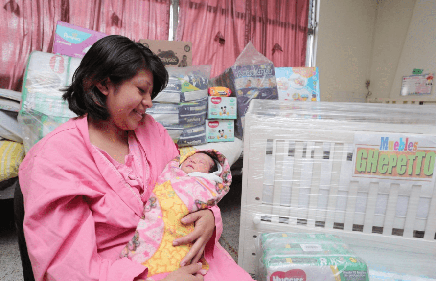 Heidy Maritza Suruy carga a su hija Adriana Isabella, quien obtuvo el primer lugar del certamen de la Maratón de la Cigüeña. (Foto Prensa Libre: Juan Diego González).