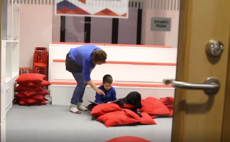 El programa busca que los perros sean asistentes durante las horas de lectura de un niño. (Foto Prensa Libre: AFP)