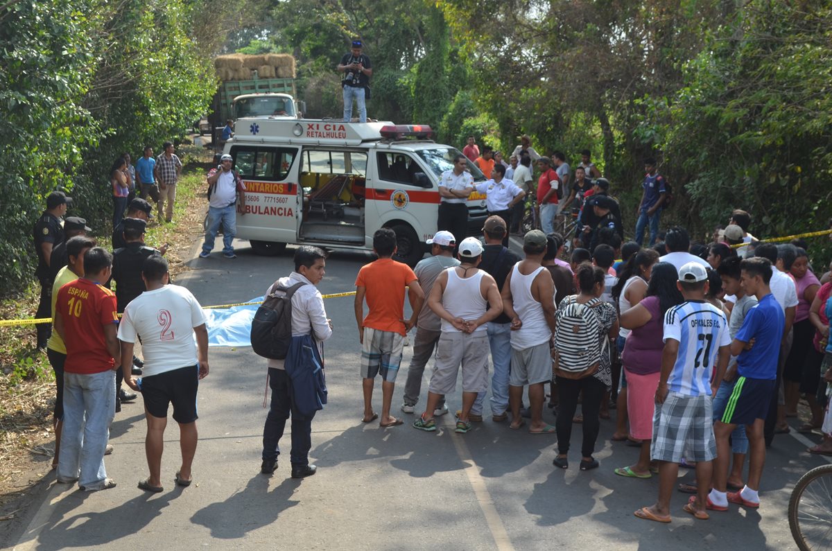 Curiosos permanecen en el lugar donde se registró el crimen en la aldea Las Delicias, Retalhuleu. (Foto Prensa Libre: Jorge Tizol).