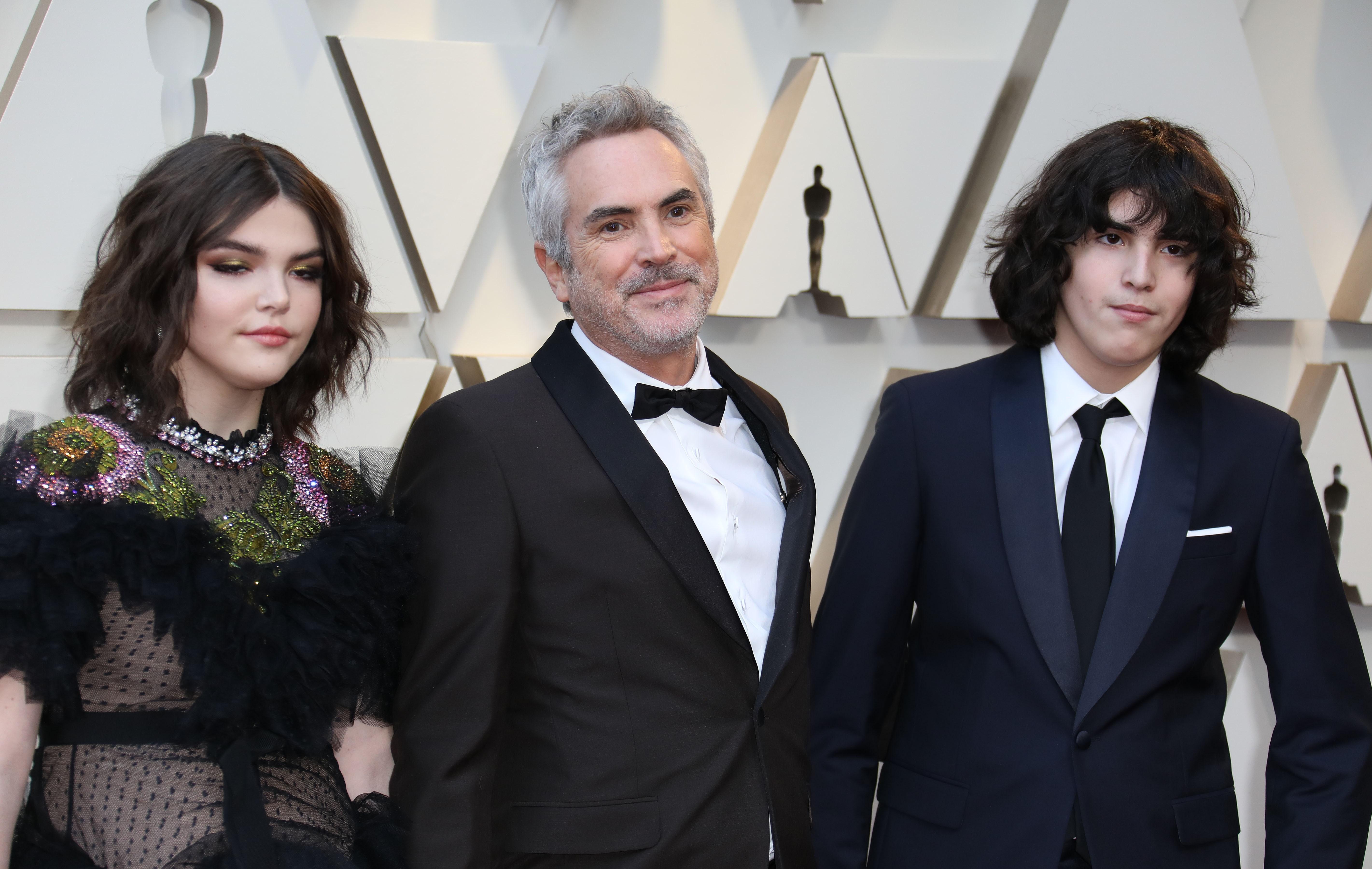 El director mexicano Alfonso Cuarón (centro) y sus hijos, Olmo Teodoro (derecha) y Tess Bu (izquierda), posan a su llegada a la alfombra roja de los Premios Óscar. (Foto Prensa Libre: EFE).