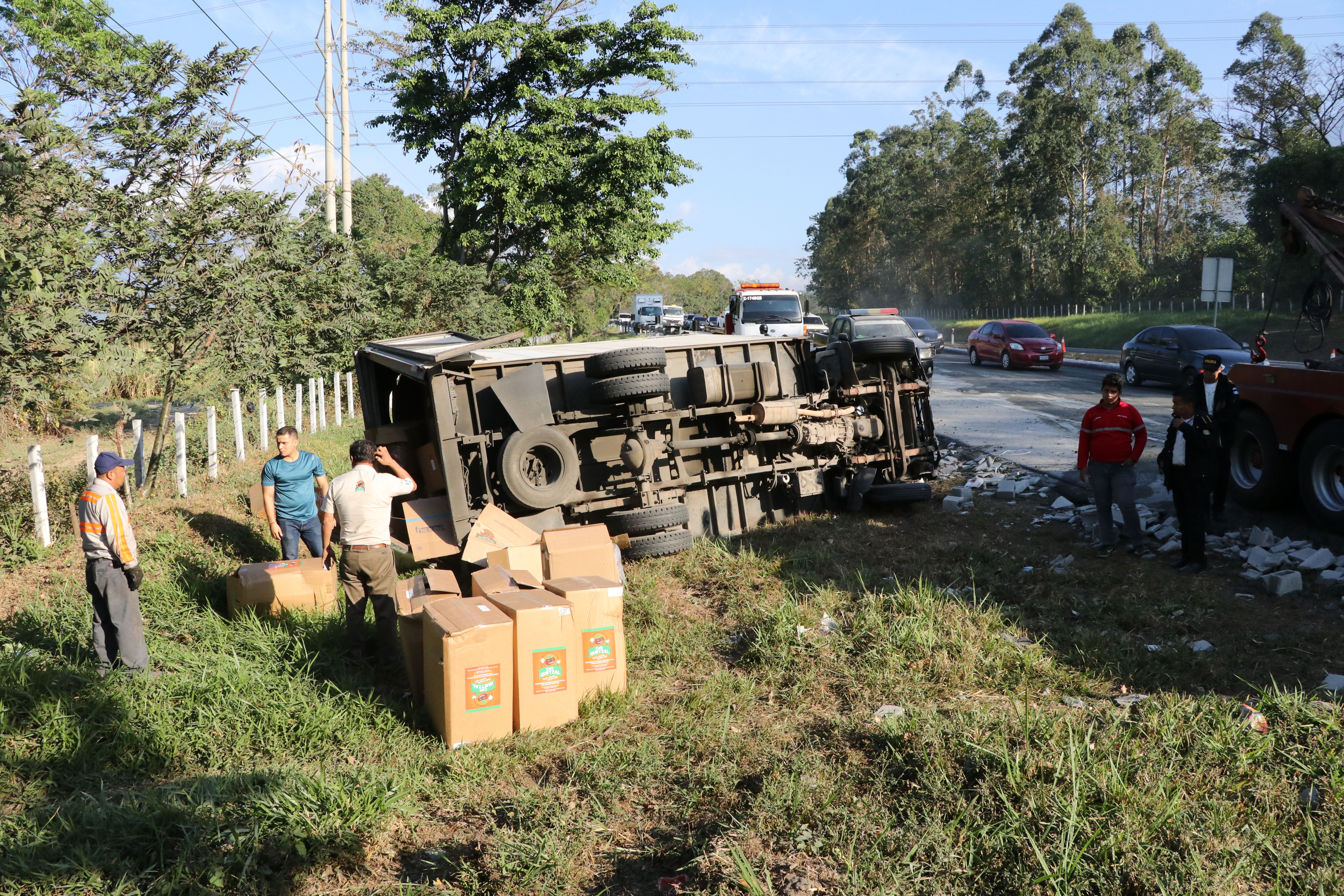 Camión que trasladaba sobres de café vuelca en la Autopista Palín-Escuintla. (Foto Prensa Libre: Hillary Paredes).