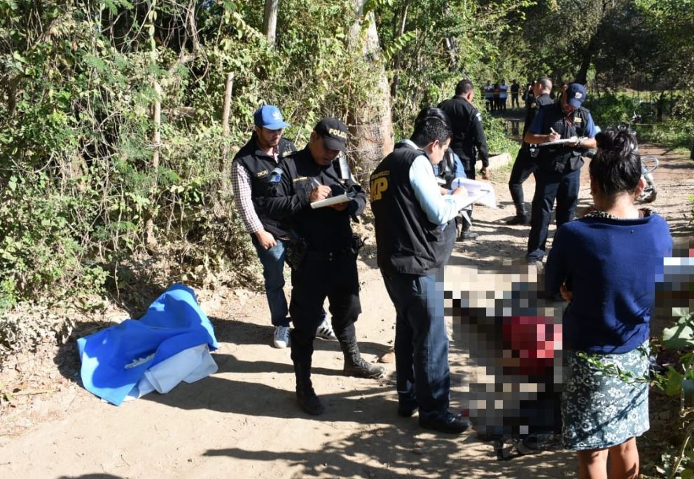 Fiscales y agentes de la PNC trabajan en el lugar donde ultimaron a padre e hijo. (Foto Prensa Libre: Mario Morales)