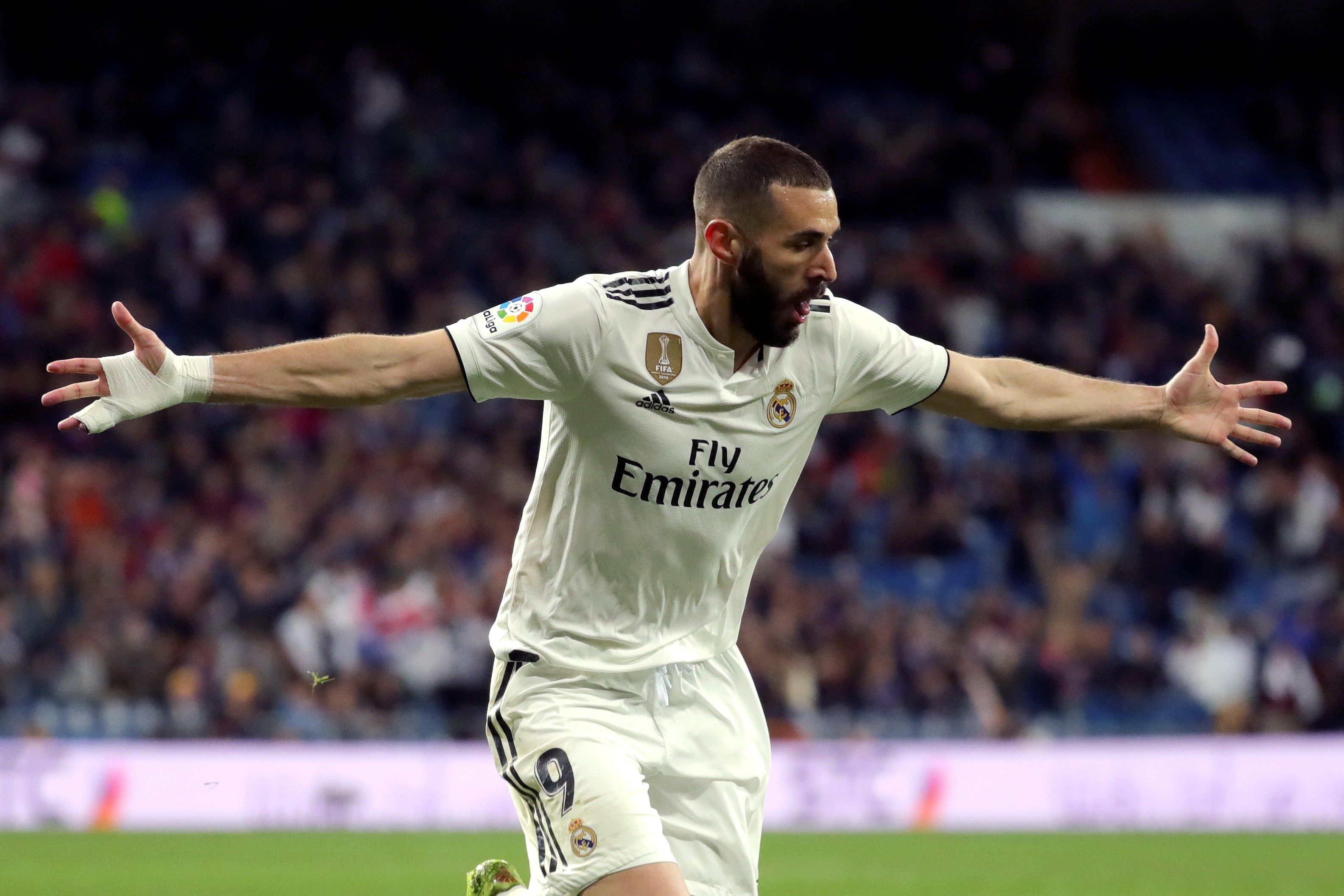 El delantero del Real Madrid Karim Benzemá celebra tras marcar el tercer gol ante el Huesca, durante el partido de Liga en Primera División disputado este domingo en el estadio Santiago Bernabéu, en Madrid. (Foto Prensa Libre: EFE)