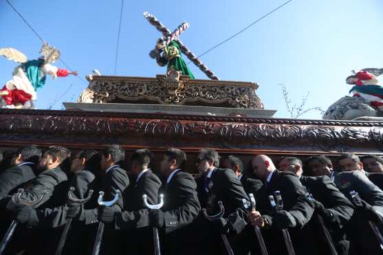 Los devotos cargadores enfilan hacia el Paseo de la Sexta Avenida después de la salida del templo