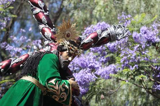 Las jacaranas sirven de marco para el paso del nazareno frente al parque Gómez Carrillo en la zona 1