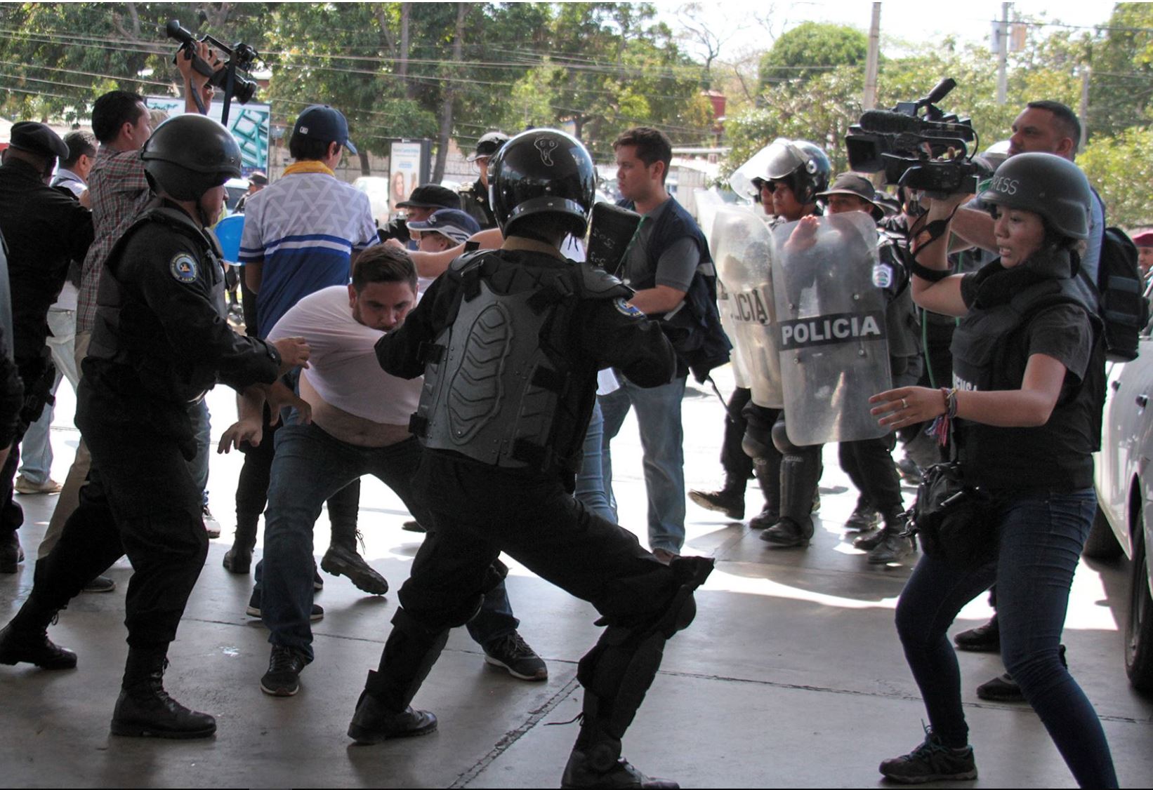 Miembros de la Policía Nacional intentan detener al reportero gráfico Luis Sequeira, de la agencia AFP, durante una manifestación contra el Gobierno de Daniel Ortega este sábado, en Managua (Nicaragua). La Policía de Nicaragua replegó con violencia este sábado a un grupo de periodistas que daban cobertura a una manifestación antigubernamental, en el marco de la grave crisis sociopolítica que afecta al país. AFP