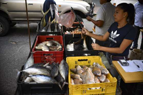 Una mujer vende pescado en un mercado callejero en Caracas, Venezuela, el 14 de marzo de 2019. Los empleados públicos de Venezuela fueron llamados a regresar al trabajo el jueves después de que el gobierno pusiera fin a una pausa de casi una semana causada por un apagón nacional sin precedentes que agudizó la ira generalizada contra Presidente Nicolás Maduro.