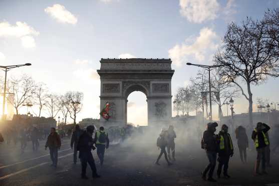 Los manifestantes  comienzan a abandonar la avenida de los Campos Elíseos, cerca del Arco de Triunfo. Foto Prensa Libre: EFE