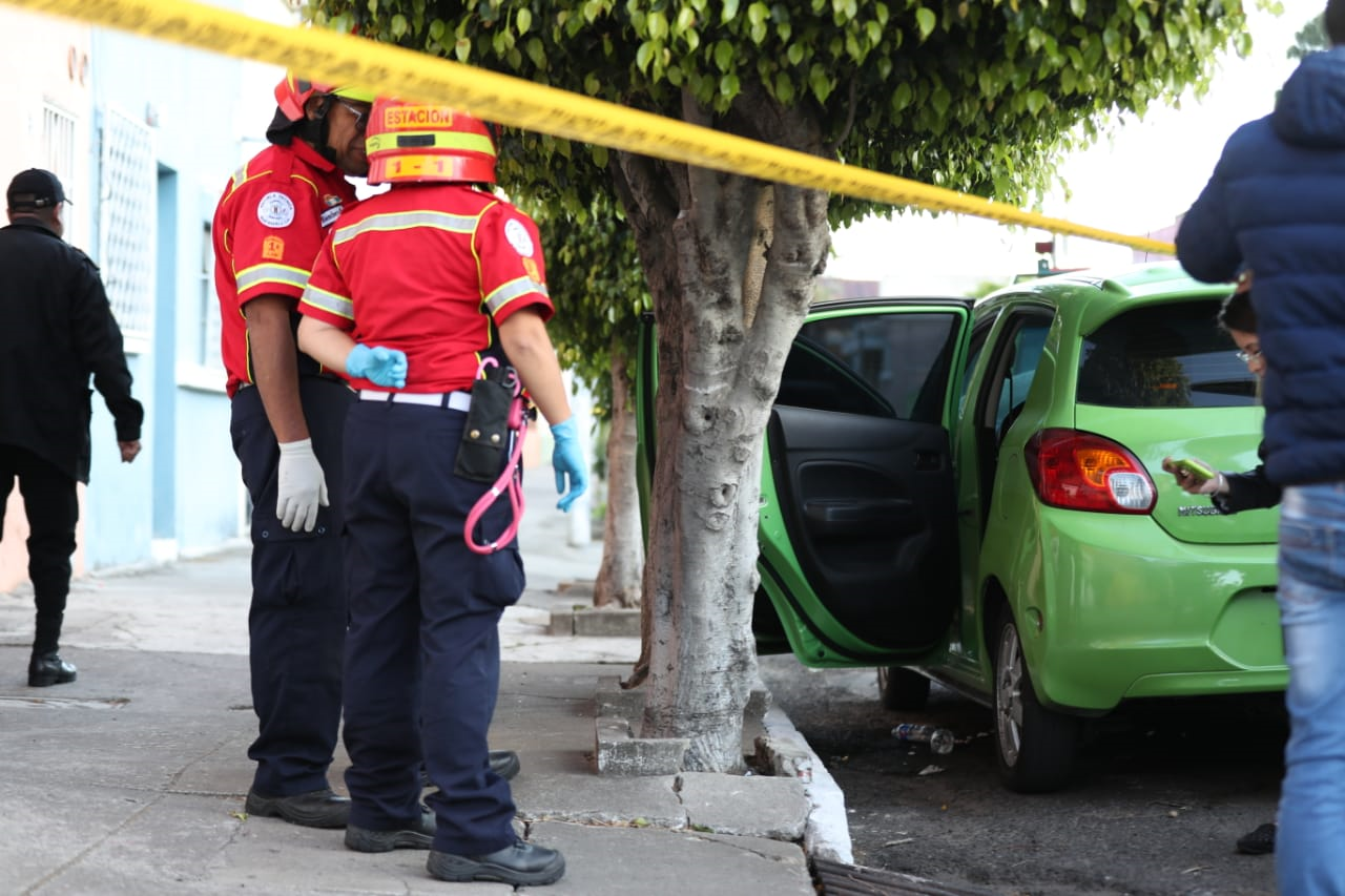 Socorristas observan las pastillas que se localizaron en el exterior del vehículo donde fue hallada la víctima. (Foto Prensa Libre: Óscar Rivas)