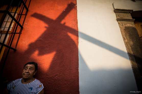 Una mujer observa el paso del nazareno en las calles previas al parque central de la ciudad colonial. Foto Prensa Libre: Jorge Cuyun