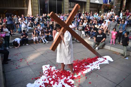 Un miembro de la iglesia sostiene una cruz durante una recreación de la Biblia, la crucifixión de Jesucristo el Viernes Santo, en Sydney, Australia. Foto Prensa Libre: AFP
