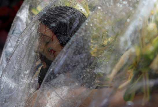 En El Salvador las imágenes fueron cubiertas con plástico debido a la lluvia. Foto Prensa Libre: AFP 
