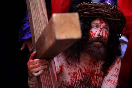 Un peregrino católico lleva una cruz a lo largo de la Vía Dolorosa (Camino del sufrimiento) mientras recrea la pasión de Jesucristo en la Ciudad Vieja de Jerusalén. Foto Prensa Libre: AFP

