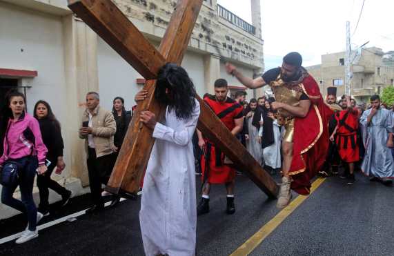 Durante la escenificación un personaje disfrazado de romano azota a otro vestido como Jesús, durante la obra presentada en Líbano. Foto Prensa Libre: AFP
