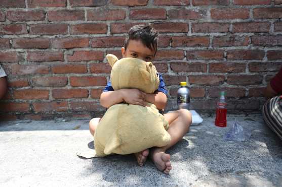 Un niño abraza su perrito de peluche.