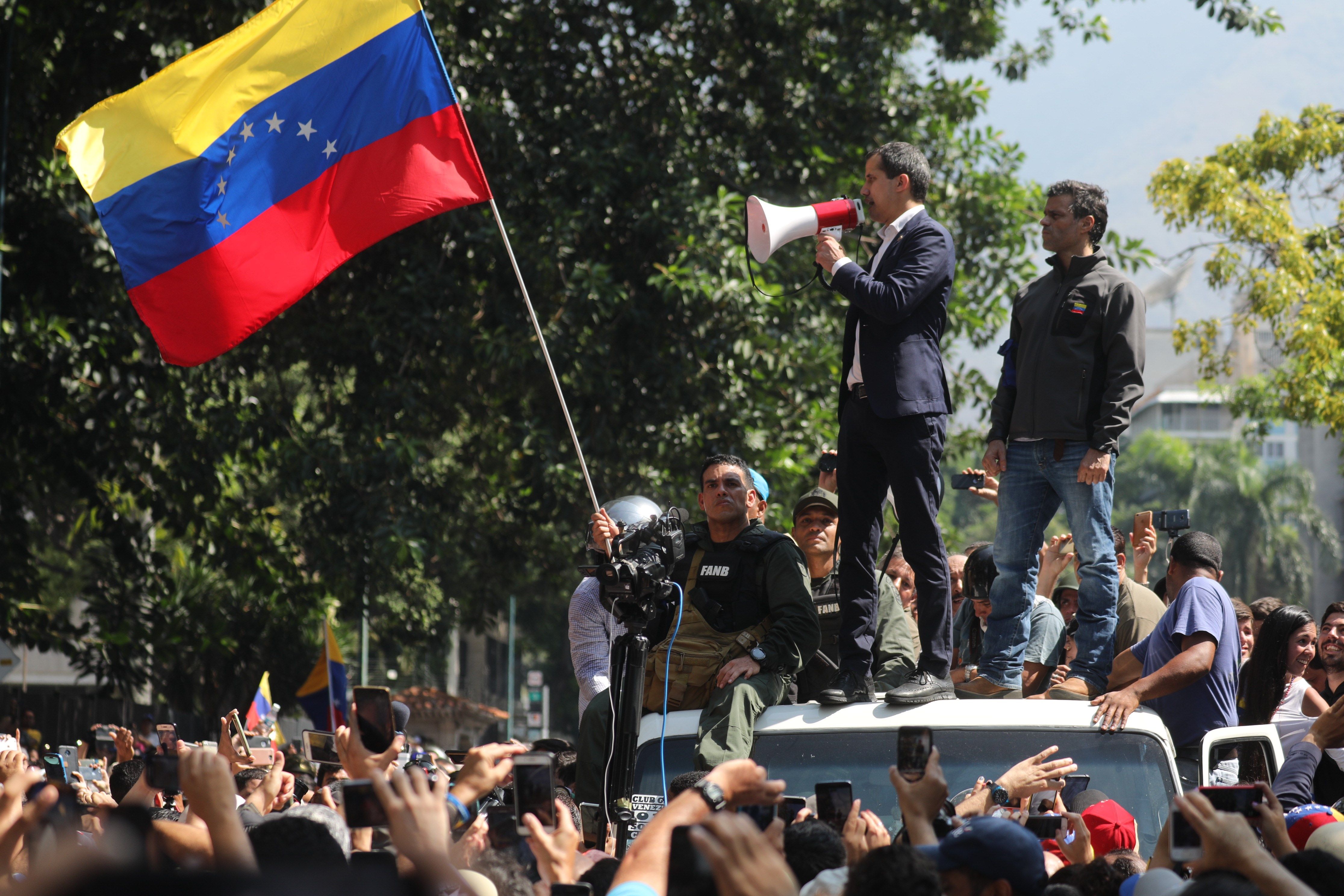 El presidente de la Asamblea Nacional, Juan Guaidó  y el líder opositor Leopoldo López participan en una manifestación en apoyo a su levantamiento. (Foto Prensa Libre: EFE)