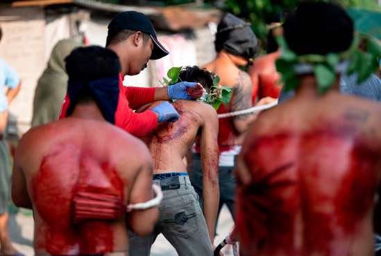 Un flagelante tiene su espalda herida para sangrar como parte de su penitencia durante la recreación de la crucifixión de Jesucristo para el Viernes Santo en San Juan, Pampanga, al norte de Manila, Filipinas. Foto Prensa Libre: AFP
