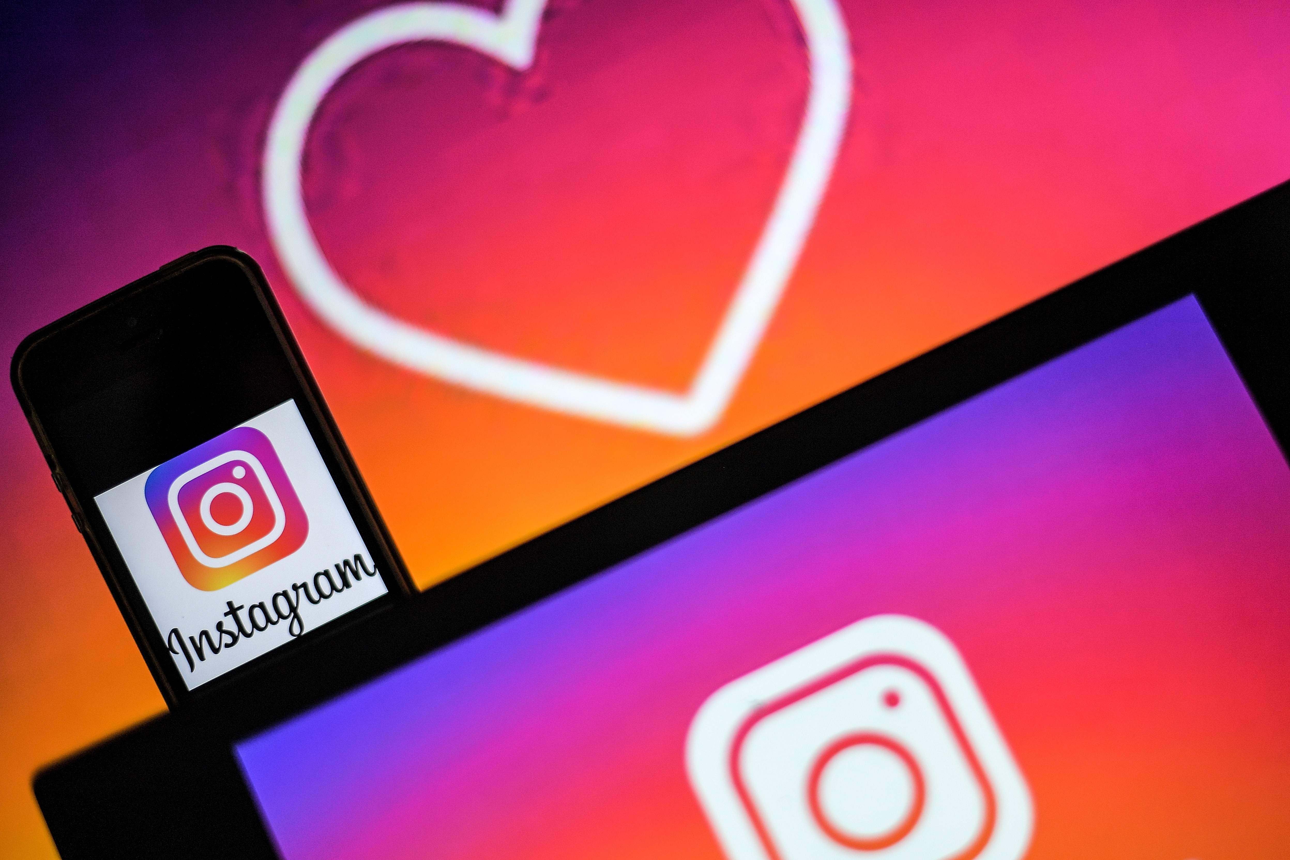 Logos of US social network Instagram are displayed on the screen of a computer and a smartphone, on May 2, 2019 in Nantes, western France. (Photo by LOIC VENANCE / AFP)