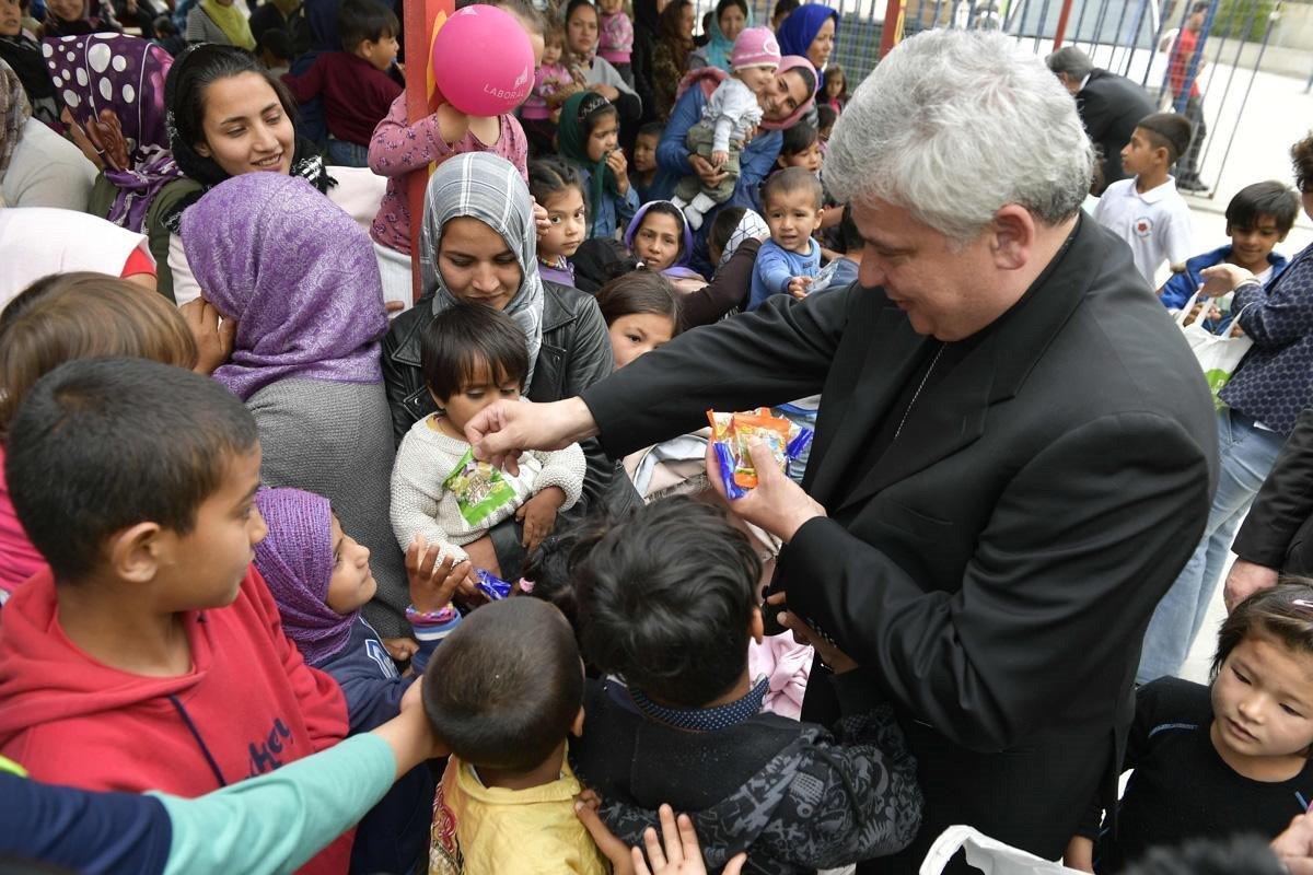  El limosnero del papa Francisco, el cardenal polaco Konrad Krajewski, reparte caramelos entre los niños durante una visita a un campamento de refugiados en las islas griegas. (Foto Prensa Libre: EFE)