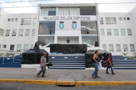 Trabajadores del edificio  Palacio de los Deportes cubren monumentos con plástico para que no sean pintados.