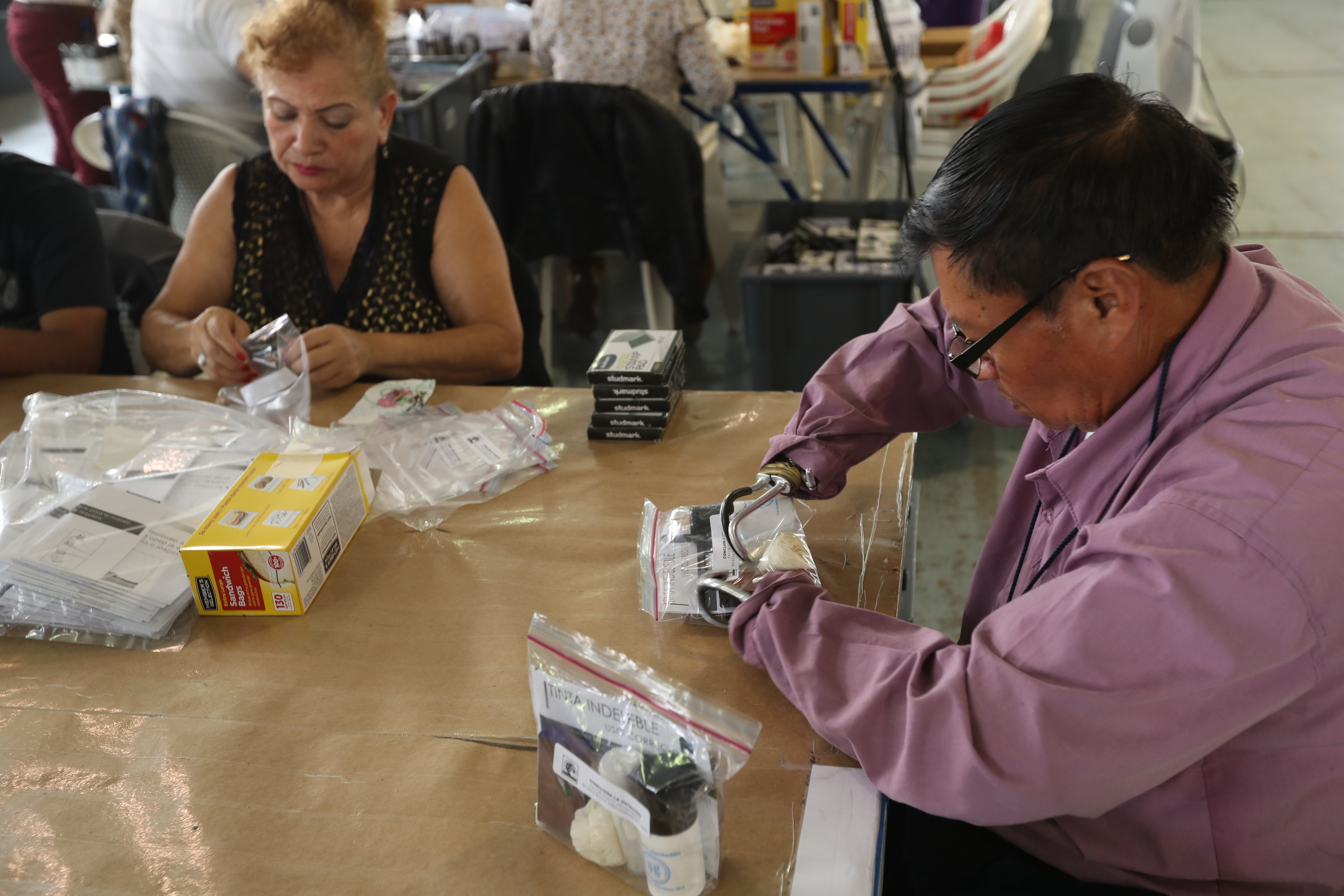 Personas con capacidades diferentes embolsan la tinta indeleble para marcar el dedo de los votantes. Fotografía Esbin Garcia