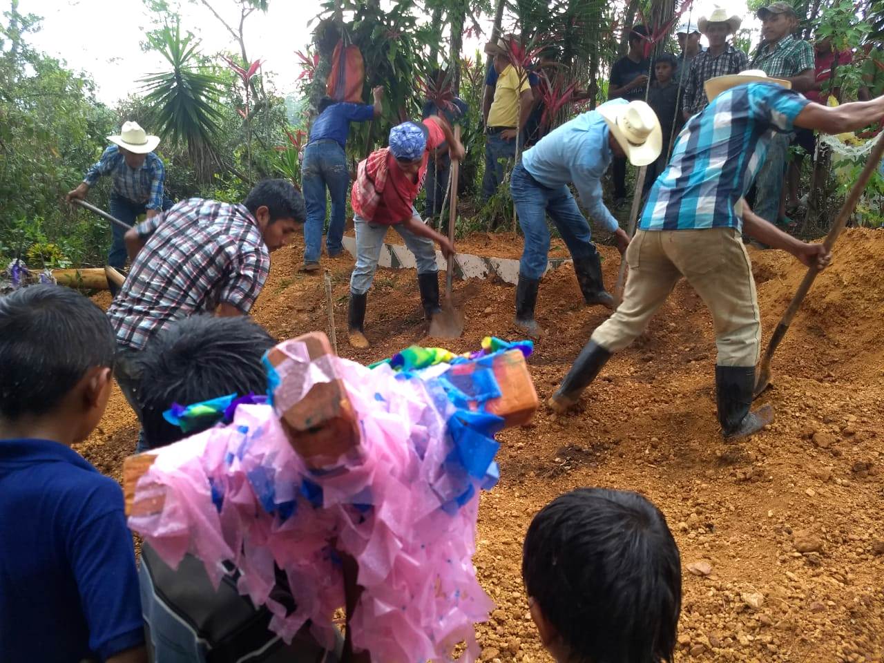 Vecinos y amigos de la familia ayudan a sepultar el féretro. La lluvia incrementó durante la sepultura. (Foto Prensa Libre: Mario Morales)
