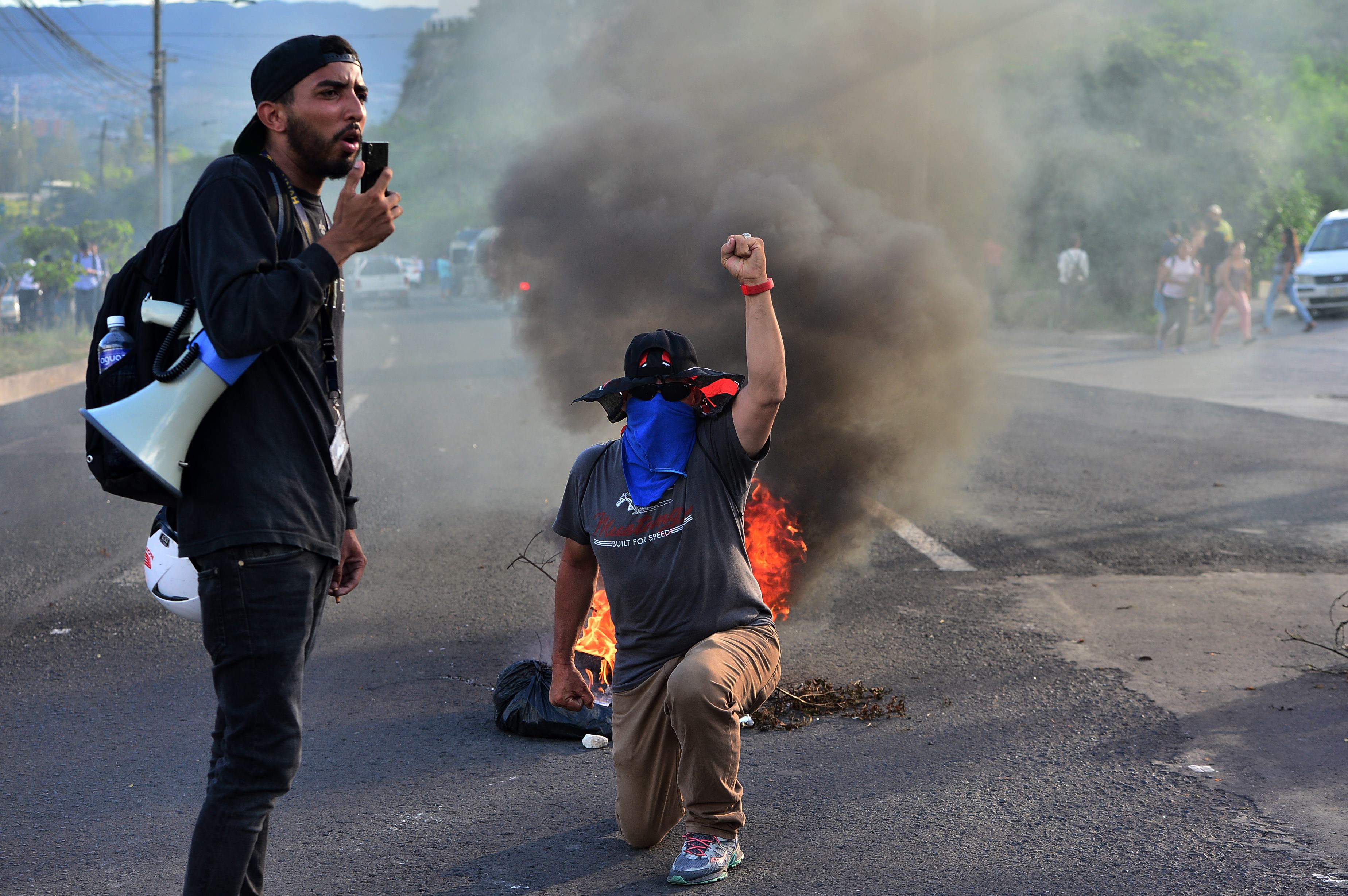 Varias personas participan en protesta contra el gobierno del presidente hondureño Juan Orlando Hernández por medidas que dicen que privatizarán los servicios de salud y educación. (Foto Prensa Libre: AFP)