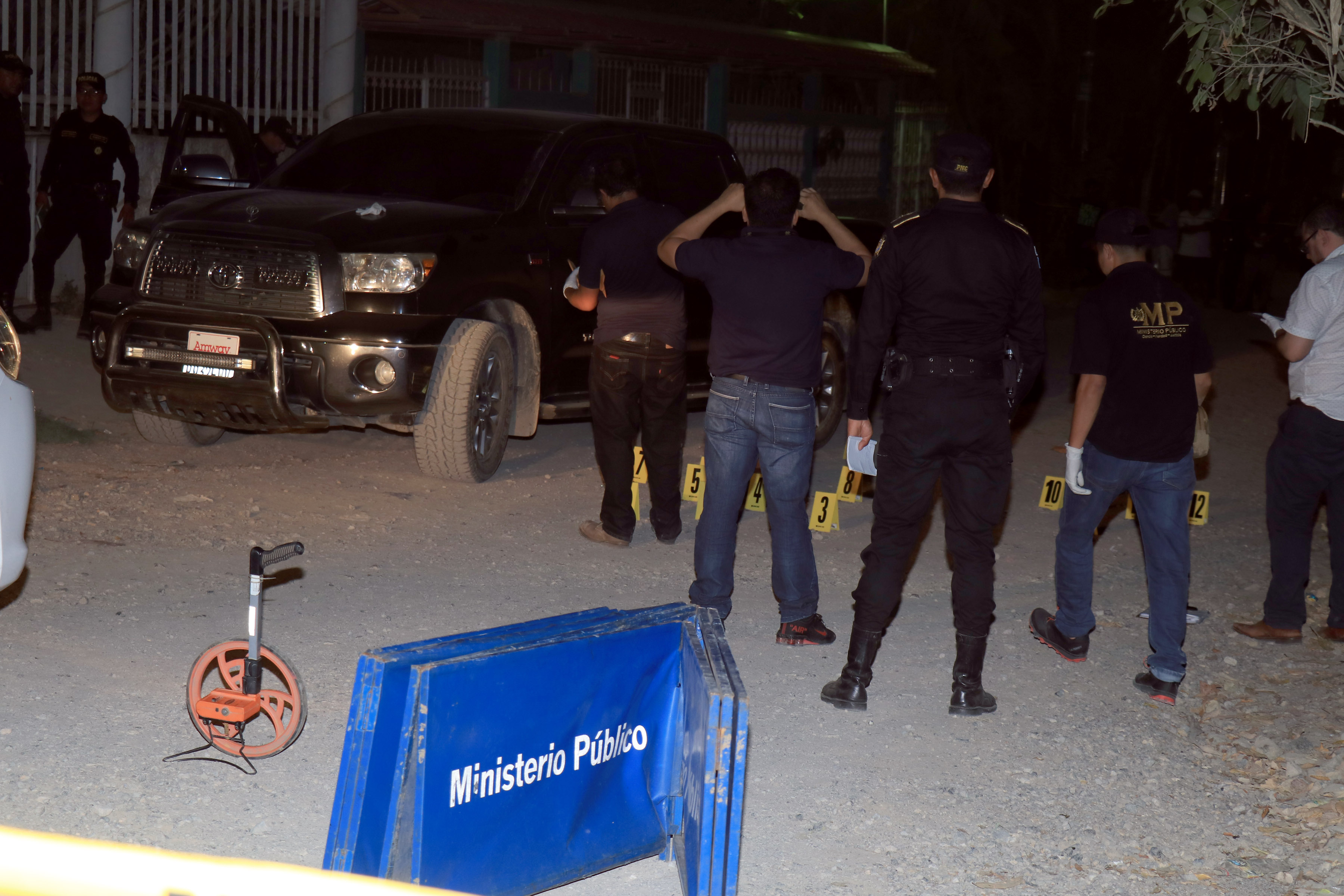 Investigadores reúnen indicios en el lugar donde murió baleado el empresario Erick Castañeda, en Puerto Barrios. (Foto Prensa Libre: Dony Stewart).