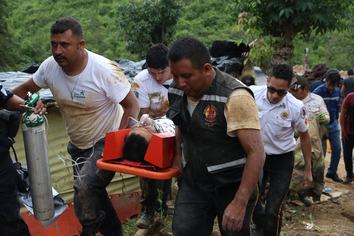 Bomberos trasladan a uno de los trabajadores que quedaron soterrados cuando hacían una zanja en Santa Catarina Pinula. (Foto Prensa Libre: @BVoluntariosGT).