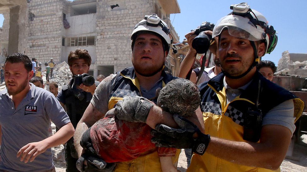 Miembros del equipo de defensa civil de Siria, conocidos como cascos blancos, rescataron vivo a un niño que resultó herido durante un bombardeo de Rusia en la provincia de Idlib. Foto: AFP