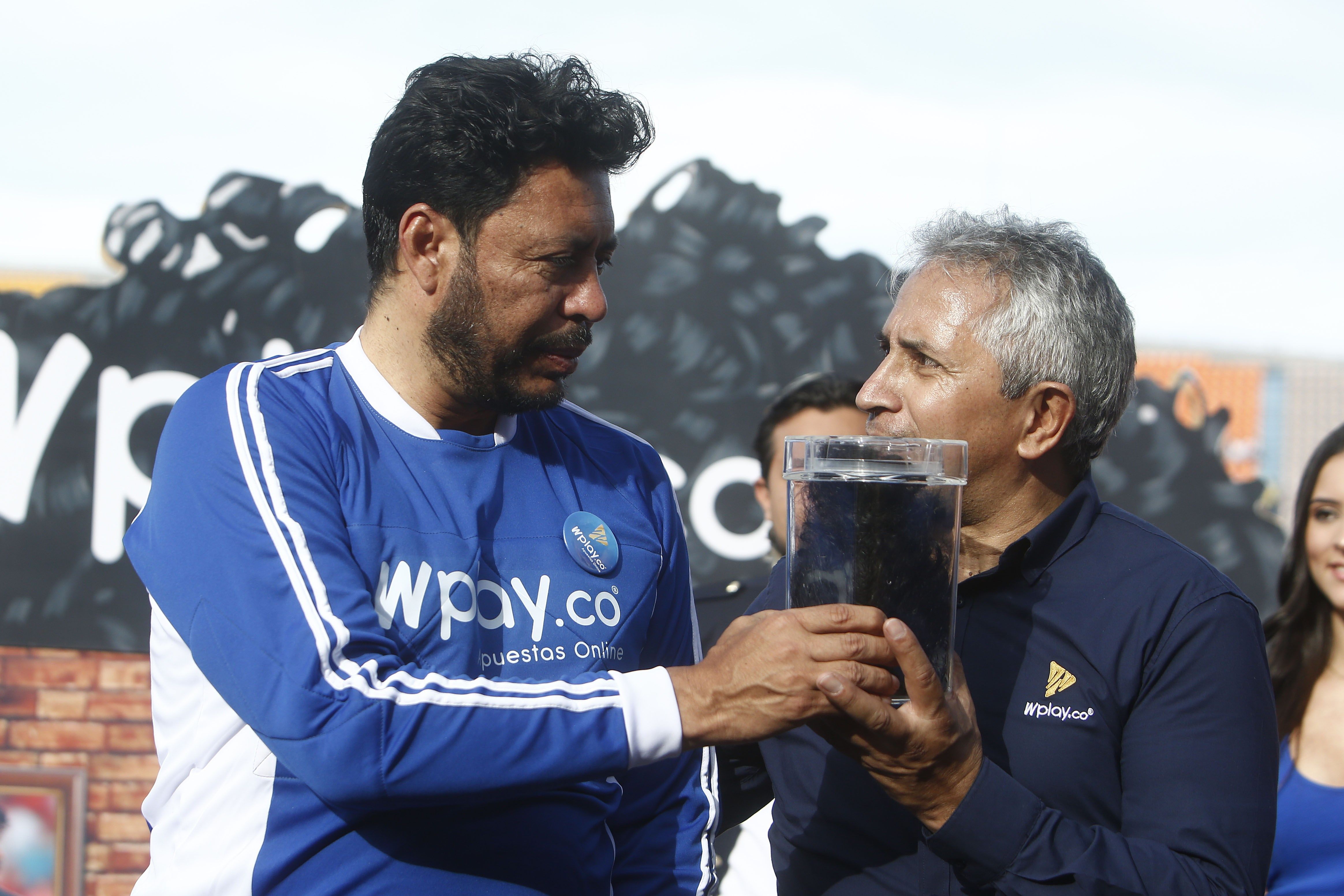 El exfutbolista colombiano René Higuita (i) entrega su cabello este sábado para una subasta, en Medelllín. (Foto Prensa Libre: EFE)